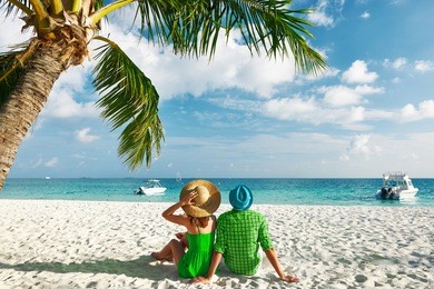 couple in green clothes on a tropical beach at maldives