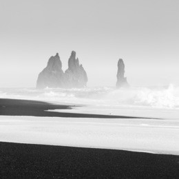 monochrome image of reynisdrangar sea stacks at vik, iceland, with black sand beach in foreground