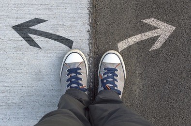 sneakers standing on a road with arrows. selective focus.