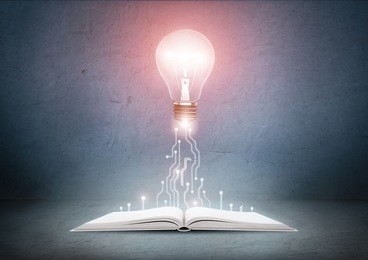open book and glowing light bulb over it. knowledge, education concept