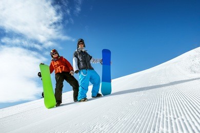 group of two snowboarders standing on the slope prepared by snowcat. sheregesh resort, siberia, russia