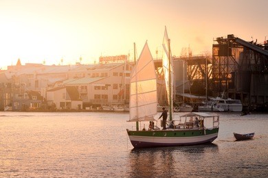 chinese style sailboat at sunset with vancouver's granville island in the background. 