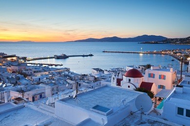 view of mykonos town and tinos island in the distance, greece.