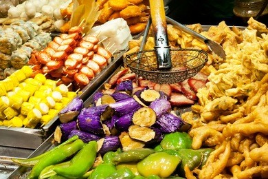tasty fried food on a street kitchen in asia. fresh vegetables, meat and fish. hong kong, china.
