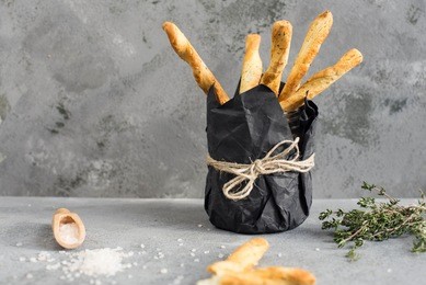 fresh baked homemade bread sticks grissini with thyme and sea salt.