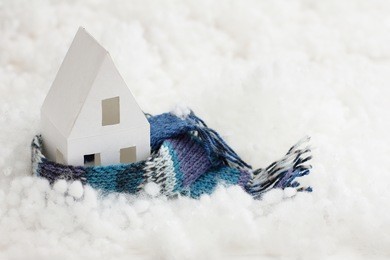 installation with winter background with a house wrapped in warm scarf