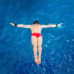 high diver, flying towards water from diving platform, shot from above