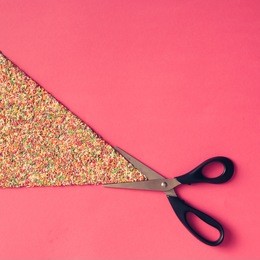 scissors and colorful sprinklers on pink background. flat lay