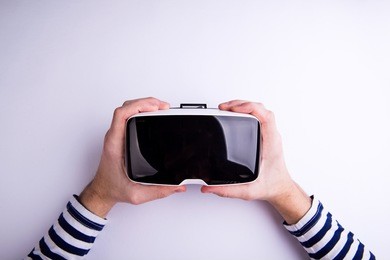 hands of man holding virtual reality goggles. flat lay
