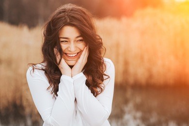 beautiful sunny portrait of a girl wearing white clothes. face laughing woman outdoors with copy space