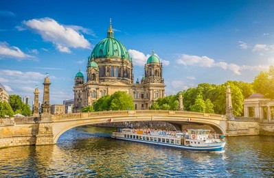 beautiful view of historic berlin cathedral (berliner dom) at famous museumsinsel (museum island) with excursion boat on spree river in beautiful evening light at sunset in summer, berlin, germany