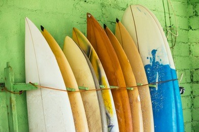 set of different color surf boards in a stack by ocean.bali,indonesia. surf boards on sandy weligama beach. on weligama beach surf is available all year around for beginner and advanced.