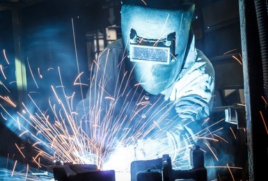 worker with protective mask welding metal