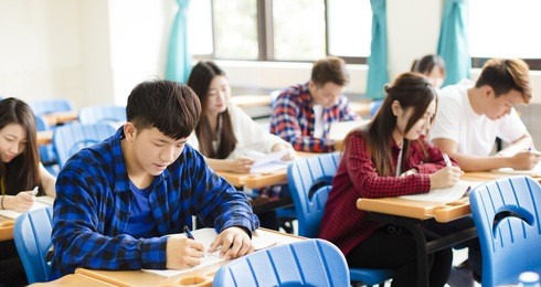 group of young students writing notes in the classroom

