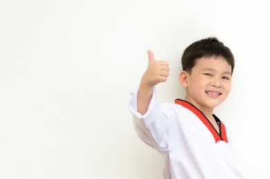 asian thai boy to happy and take confidence concept by taekwondo uniform