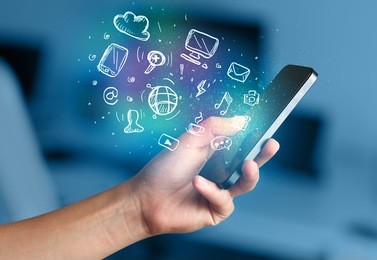 hand holding smartphone with glowing multimedia icons 