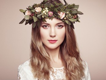 beautiful blonde woman with flower wreath on her head. beauty girl with flowers hairstyle. perfect makeup. beauty fashion. spring woman