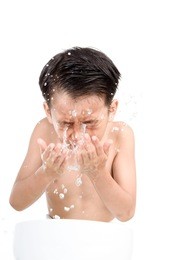 young boy wash his face by fresh water in white bathroom.