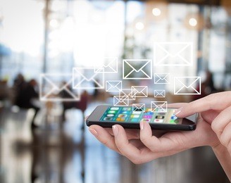 smart phone emitting holographic image of social media related icons. hand touching touch pad, social media concept. blurred city background.