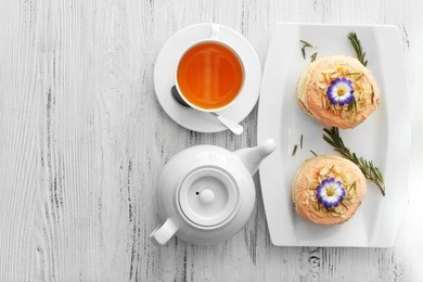 tea with cakes on wooden background, top view