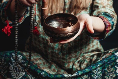 tibetan singing bowl in the hands of a girl in national costume