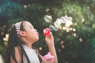 cute asian girl is blowing a soap bubbles,vintage filter