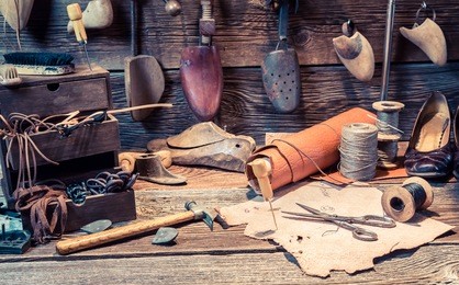 vintage cobbler workplace with tools, leather and shoes