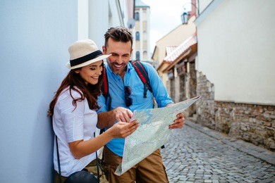 happy couple on vacation sightseeing city with map