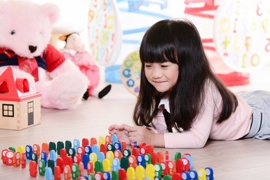 child little girl playing wooden toys at home or kindergarten