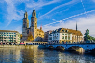 view of a quay of river limmat in the swiss city zurich which is dominated by the town hall on one side and grossmunster cathedral on the other