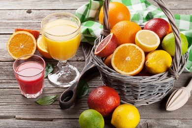 citrus fruits in basket and juice glasses. orange, lemon, lime.