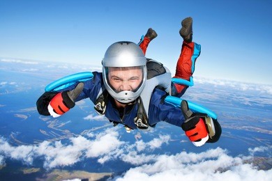 skydiver falls through the air. all right! thumbs up! parachuting is fun!
