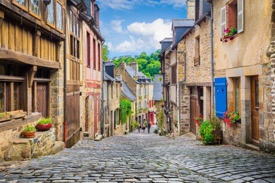beautiful view of scenic narrow alley with historic traditional houses and cobbled street in an old town in europe with blue sky and clouds in summer with retro vintage instagram grunge filter effect