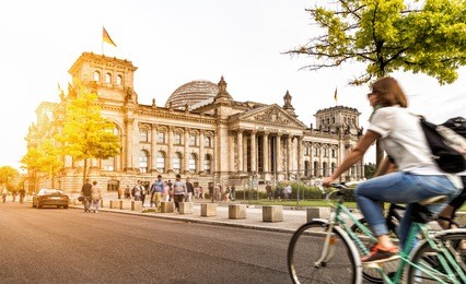 urban city life with famous reichstag building in the background in beautiful golden evening light at sunset in summer with retro vintage instagram style pastel toned filter effect, berlin, germany