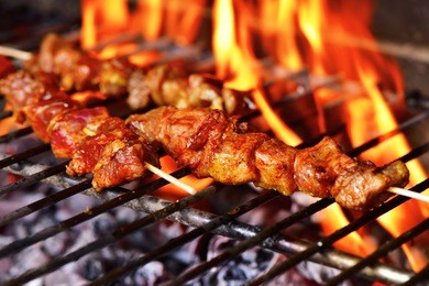 closeup of some meat skewers being grilled in a barbecue