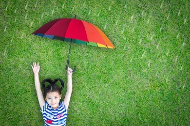health care insurance concept for family and children medical healthcare protection, flu prevention immunization with happy asian school girl kid holding umbrella under the rain on green lawn