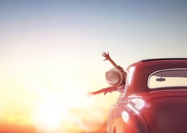 toward adventure! girl relaxing and enjoying road trip. happy girl rides into the sunset in vintage car.