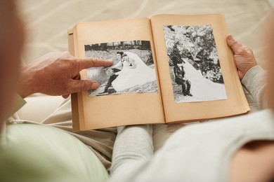senior couple at their wedding photos in photo album