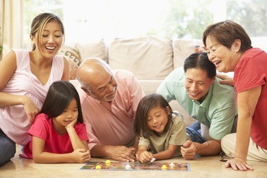extended family group playing board game at home