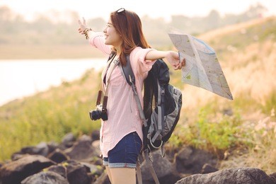 freedom traveler woman standing with raised arms and enjoying a beautiful nature