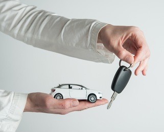hand with keys and car on white background. car insurance. automobile collision damage waiver concepts. with protective gesture and icon of car. protection of car. business concept.