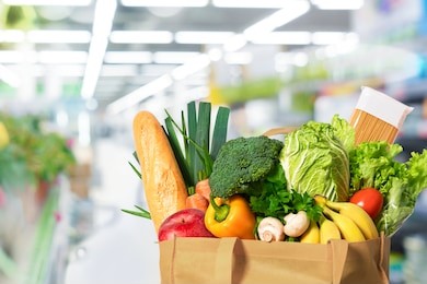 eco friendly reusable shopping bag filled with vegetables on th supermarket background