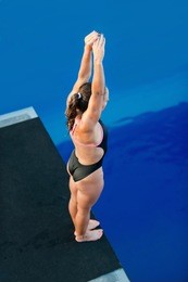 female diver on platform, preparing to dive
