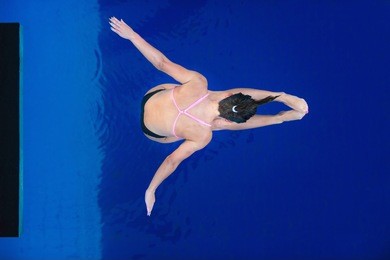 lady platform diver in air, shot from above