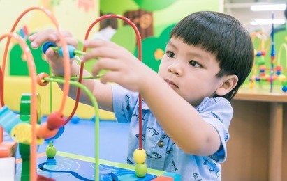 asian baby playing with educational toy