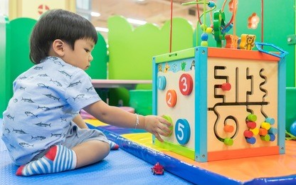 asian baby playing with educational toy
