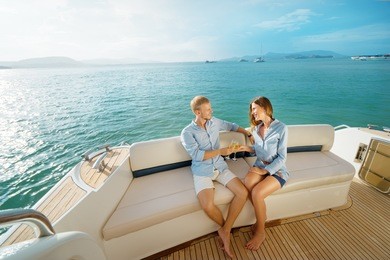 romantic vacation and luxury travel. young loving couple sitting on the sofa on the modern yacht deck. sailing the sea.