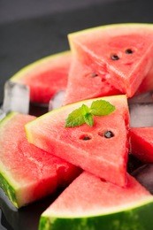 fresh ripe watermelon slices and ice on black background, selective focus