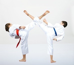 a guy with a blue belt and a girl with a red belt makes a high kick