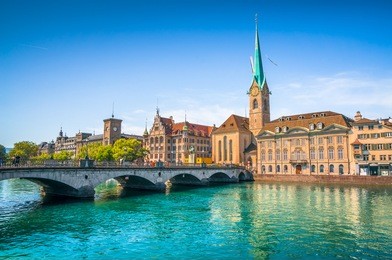 panoramic view of the historic city center of zurich with famous fraumunster church and munsterbrucke with river limmat on a sunny day with blue sky, canton of zurich, switzerland